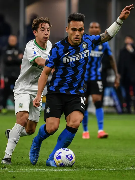 Pemain depan Inter Milan, Lautaro Martinez (kanan) mengontrol bola di dekat gelandang Sassuolo, Maxime Lopez pada laga tunda Liga Italia di Stadio Giuseppe Meazza, Kamis (8/4/2021) dini hari WIB. Bermain di kandang, Inter Milan mengalahkan Sassuolo dengan skor 2-1. (Isabella BONOTTO / AFP)