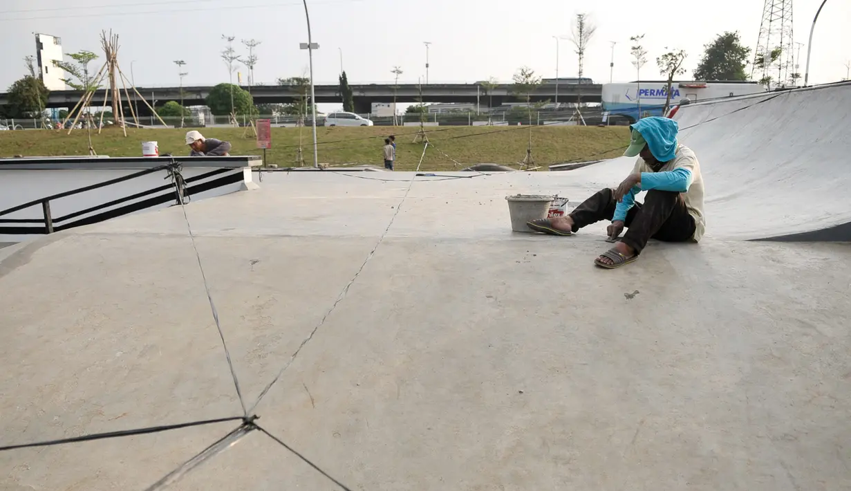 Pekerja menampal arena skate yang bolong di RPTRA Kalijodo, Jakarta, Selasa (6/6). Untuk menjaga kenyamanan saat bermain, arena skatepark RPTRA kalijodo yang rusak diperbaiki. (Liputan6.com/Yoppy Renato)