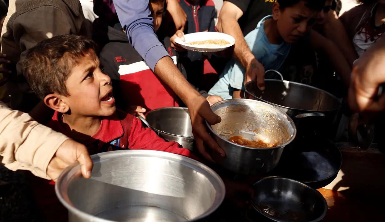 Sejumlah anak saat mengambil makanan saat mengungsi di kamp Khazer, Irak, (11/11). Warga terpaksa melarikan diri saat Pasukan Irak dan kelompok militan ISIS bentrok memberebutkan kota Mosul. (REUTERS/Zohra Bensemra)