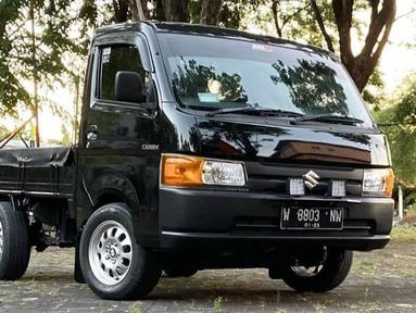 Carry hitam ini mengusung konsep OEM look dengan aksen lampu sein berwarna orange. Velg yang digunakan merupakan copotan kepunyaan BMW E46 318i. (Source: Instagram/@suzukinewcarryindonesia)