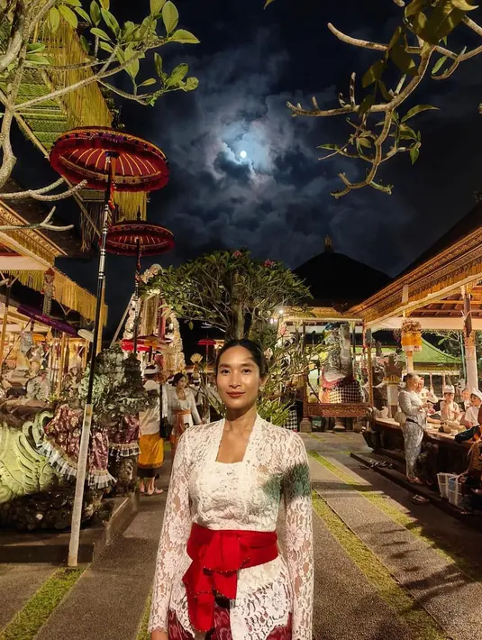 Happy Salma tampil eksotis dengan kebaya Bali berwarna putih lengkap dengan selendang merah [@happysalma]