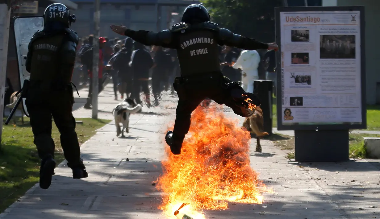 Seorang polisi melompati bom molotov yang dilempar oleh para demonstran di Santiago , Chile , 21 April 2016. Para Demonstran menuntut perubahan sistem pendidikan di Chile. (REUTERS / Clemente Villavicencio)