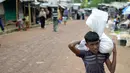 Seorang anak Rohingya membawa bantuan di kamp pengungsi Kutupalong, di Ukhia, Bangladesh pada 6 Oktober 2020. Lebih dari satu juta etnis Rohingya melarikan diri dari Myanmar dan menetap di Kutupalong yang merupakan salah satu kamp pengungsi terbesar di dunia. (Munir Uz Zaman/AFP)