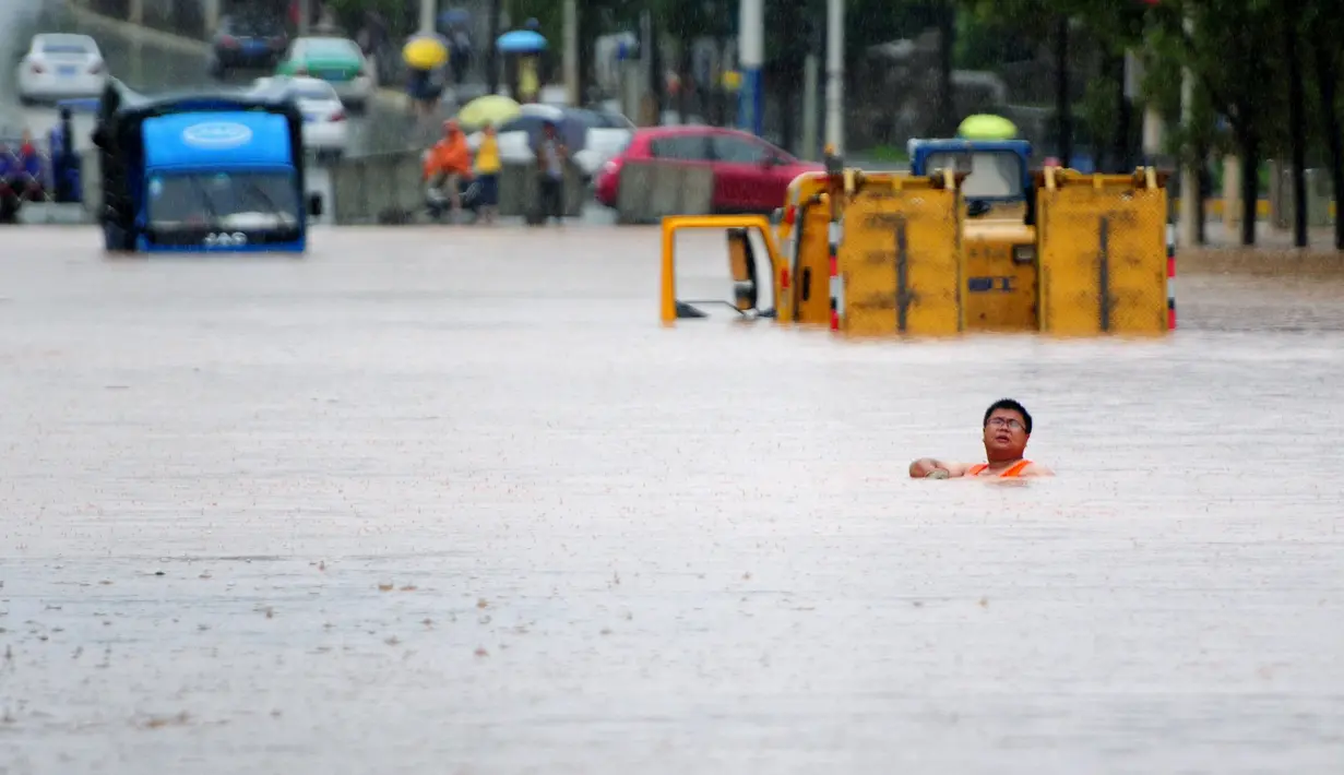 Seorang pria berjalan melewati banjir di Jiujiang , Provinsi Jiangxi , Cina , (19/2). Banjir yang tinggi menyendat lalu lintas Kota Jiujiang. (REUTERS/ China Daily)