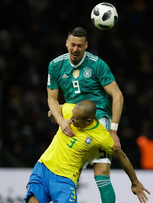Pemain timnas Jerman Sandro Wagner berebut bola dengan pemain timnas Brasil, Miranda pada laga uji coba di Olympiastadion Berlin, Selasa (27/3). Brasil sukses menaklukkan Jerman dengan skor 1-0. (AP Photo/Michael Sohn)