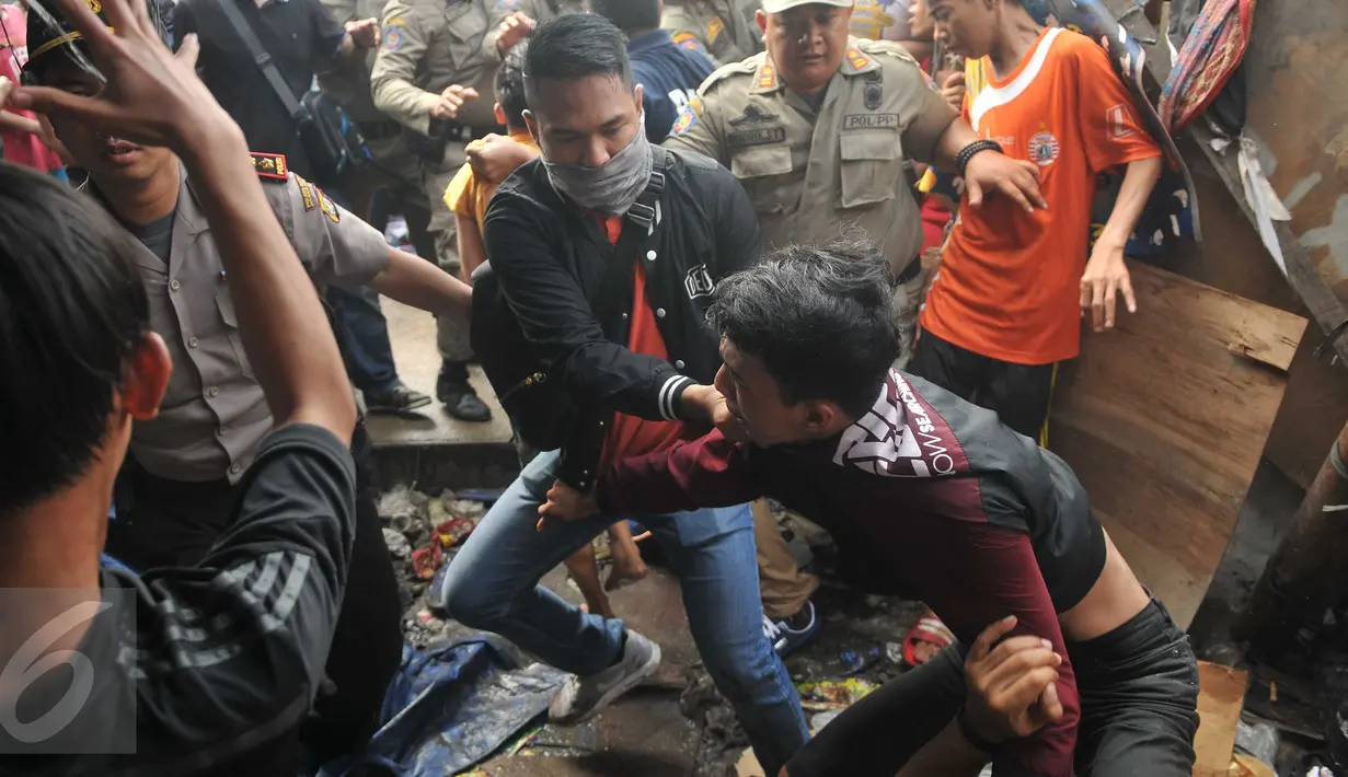 Seorang remaja dibawa paksa oleh aparat keamanan saat penggusuran di kawasan Pasar Ikan, Penjaringan, Jakarta, Senin (11/4). Bentrokan sempat terjadi antara petugas dan warga yang menolak penggusuran di kawasan tersebut (Liputan6.com/Gempur M Surya)