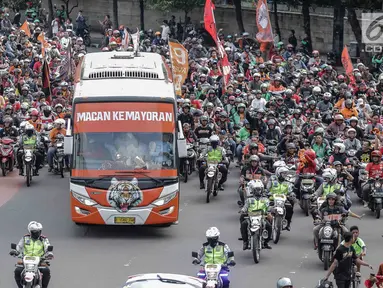 Bus yang membawa pemain Persija, pelatih dan ofisial tim memimpin Pawai Juara Piala Presiden 2018 di kawasan Sudirman, Jakarta, Minggu (18/2). Konvoi arak-arakan dimulai dari Stadion Utama Gelora Bung Karno menuju Balai Kota. (Liputan6.com/Faizal Fanani)