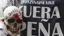 Demonstran  memegang tengkorak saat pawai peringatan 14 bulan hilangnya mahasiswa Universitas Ayotzinapa Raul Isidro Burgos di Mexico City, Meksiko, (26/11). Demonstran turun kejalan untuk menuntut keadilan 43 siswa yang hilang. (REUTERS/Daniel Becerril)