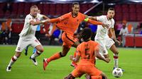 Bek Belanda, Virgil van Dijk, berebut bola dengan pemain Polandia pada laga UEFA Nations League di Stadion Johan Cruijff Arena, Amsterdam, Sabtu (5/9/2020) dini hari WIB. Belandang menang 1-0 atas Polandia. (AFP/John Thys)