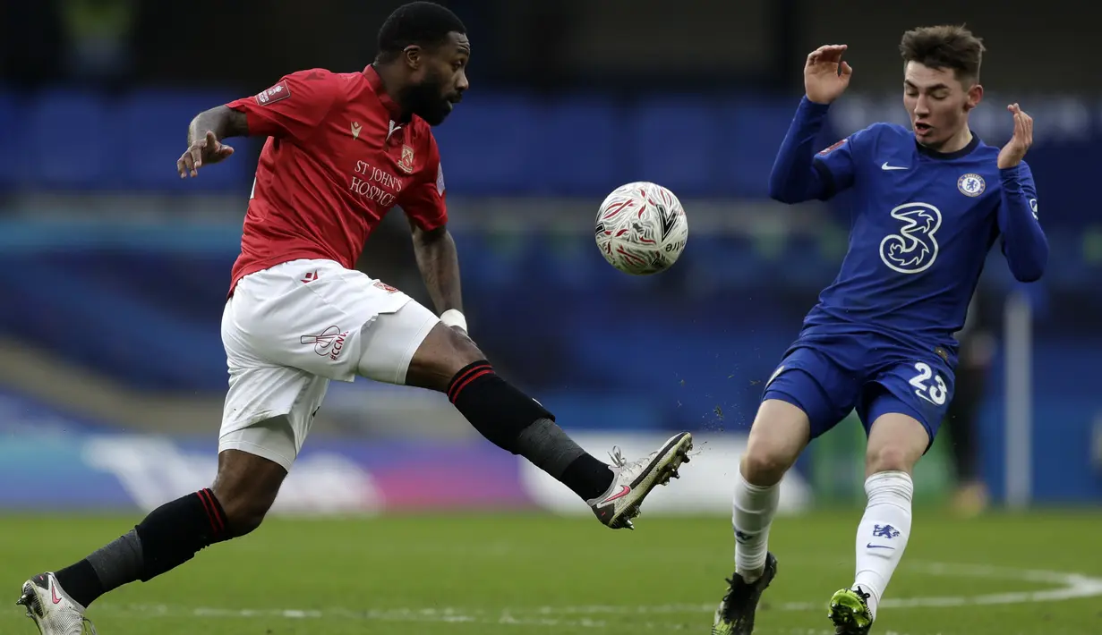 Gelandang tim divisi empat Morecambe, Yann Songo'o (kiri) berebut bola dengan gelandang Chelsea, Billy Gilmour pada babak ketiga Piala FA 2020/21 di Stamford Bridge, Minggu (10/1/2021). Chelsea menggasak Morecambe dengan skor telak 4-0. (AP Photo/Matt Dunham)