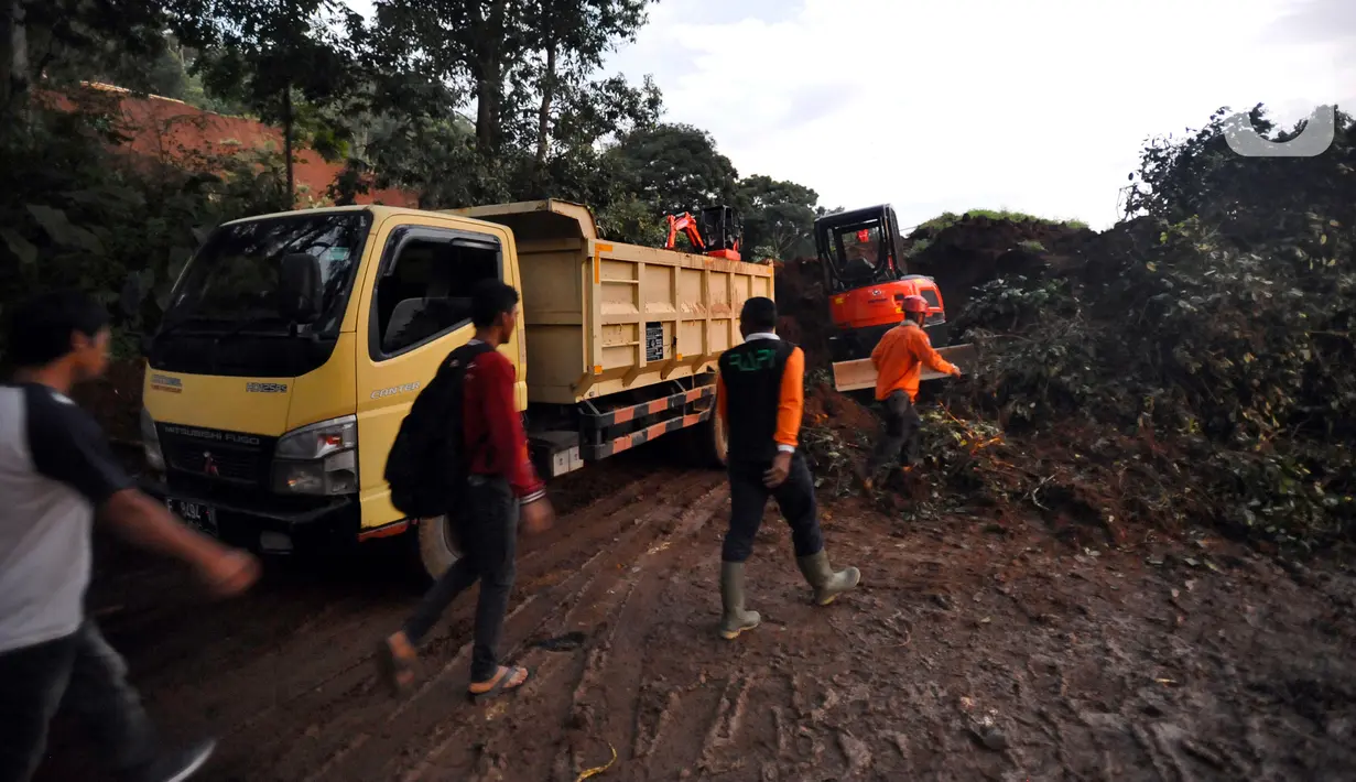 Warga melewati longsor yang menutup ruas jalan utama Cipanas-Cianjur akibat gempa bumi di kawasan Cugenang, Cianjur, Jawa Barat, Senin (21/11/2022). Longsor membawa sebuah angkot yang diduga berisi penumpang dan truk ke dalam jurang, evakuasi pun akan dilanjutkan esok hari. (merdeka.com/Arie Basuki)