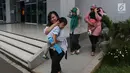 Para ibu berlari sambil melindungi kepala anak mereka dengan tangan saat simulasi bencana di Gedung Graha BNPB, Jakarta, Kamis (26/4). (Liputan6.com/Arya Manggala)