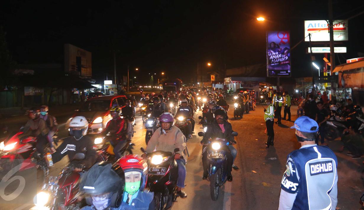 Sejumlah petugas memantau arus lalu lintas di jalur simpang Cikalong, Jawa Barat, Jumat (1/7) dini hari. H-5 Lebaran, ratusan pemudik yang menggunakan sepeda motor mulai memadati jalur pantura menuju Jawa Tengah. (Liputan6.com/Angga Yuniar)