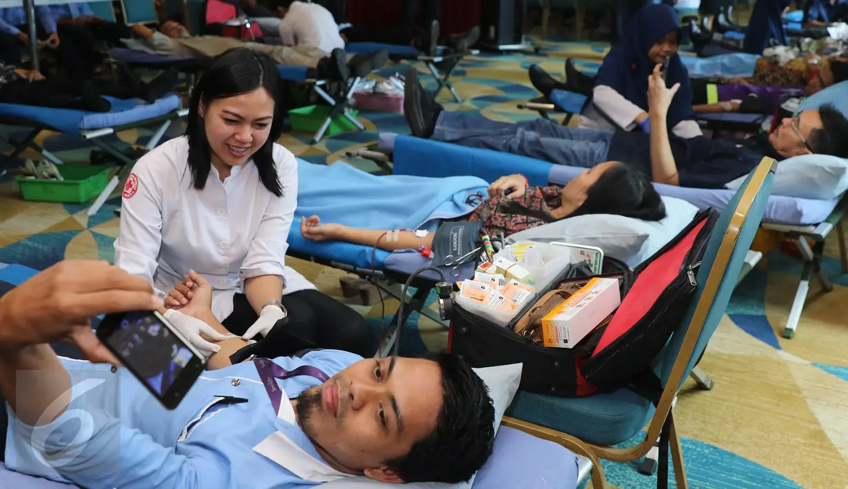 Seorang pekerja berselfie saat melakukan donor darah di kawasan Senayan, Jakarta, Rabu (13/4). Dalam kegiatan tersebut Senayan City juga mengkampanyekan gaya hidup sehat dengan olahraga. (Liputan6.com/Herman Zakharia)