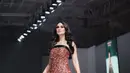 Luna Maya memancarkan pesona bak dewi dalam balutan strapless dress hitam berhiaskan beads emas berkilauan rancangan Christie Basil di JFW 2025.