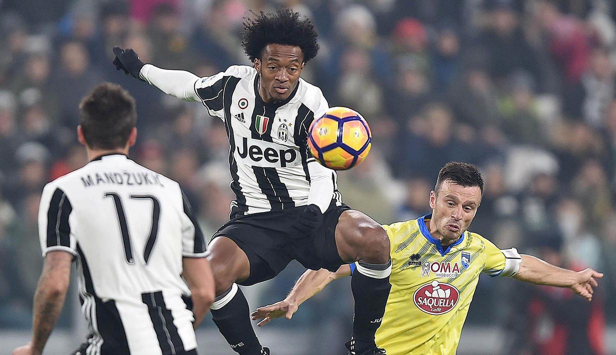 Gelandang Juventus, Juan Cuadrado, berusaha membuang bola dari pemain Pescara, Ledian Memushaj. Kekalahan ini membuat Pescara kian terpuruk di zona degradasi. (EPA/Alessandro Di Marco)