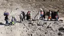 Orang-orang yang melarikan diri dari pengeboman Israel di Lebanon, berjalan di sekitar area lubang yang disebabkan oleh serangan Israel, di daerah Masnaa di sisi perbatasan Lebanon dengan Suriah, pada 4 Oktober 2024. (HASSAN JARRAH/AFP)