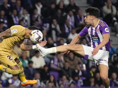 Pemain Real Valladolid, Alvaro Aguado, berebut bola dengan pemain Barcelona, Raphinha, pada laga pekan ke-36 La Liga di di Estadio Municipal Jose Zorilla, Rabu (24/5/2023). Barca takluk 1-3 dari tuan rumah Real Valladolid. (AP Photo/Manu Fernandez)