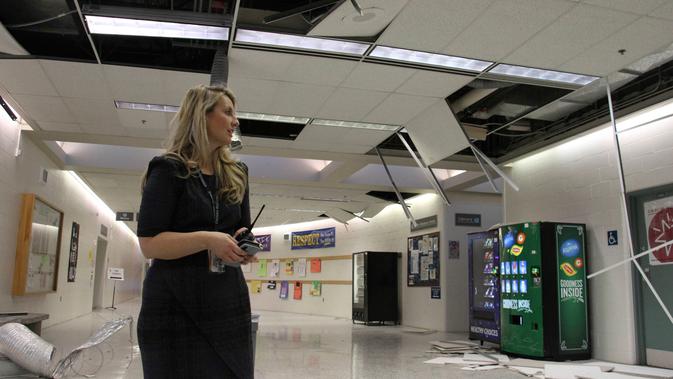 Allison Susel, kepala sekolah Chugiak High School melihat kerusakan menyusul gempa bumi di Chugiak, Alaska, Jumat (30/11). Gempa bermagnitudo 7.0 itu merobohkan langit-langit sekolah dan melemparkan buku-buku dari rak di perpustakaan (AP/Mark Thiessen)