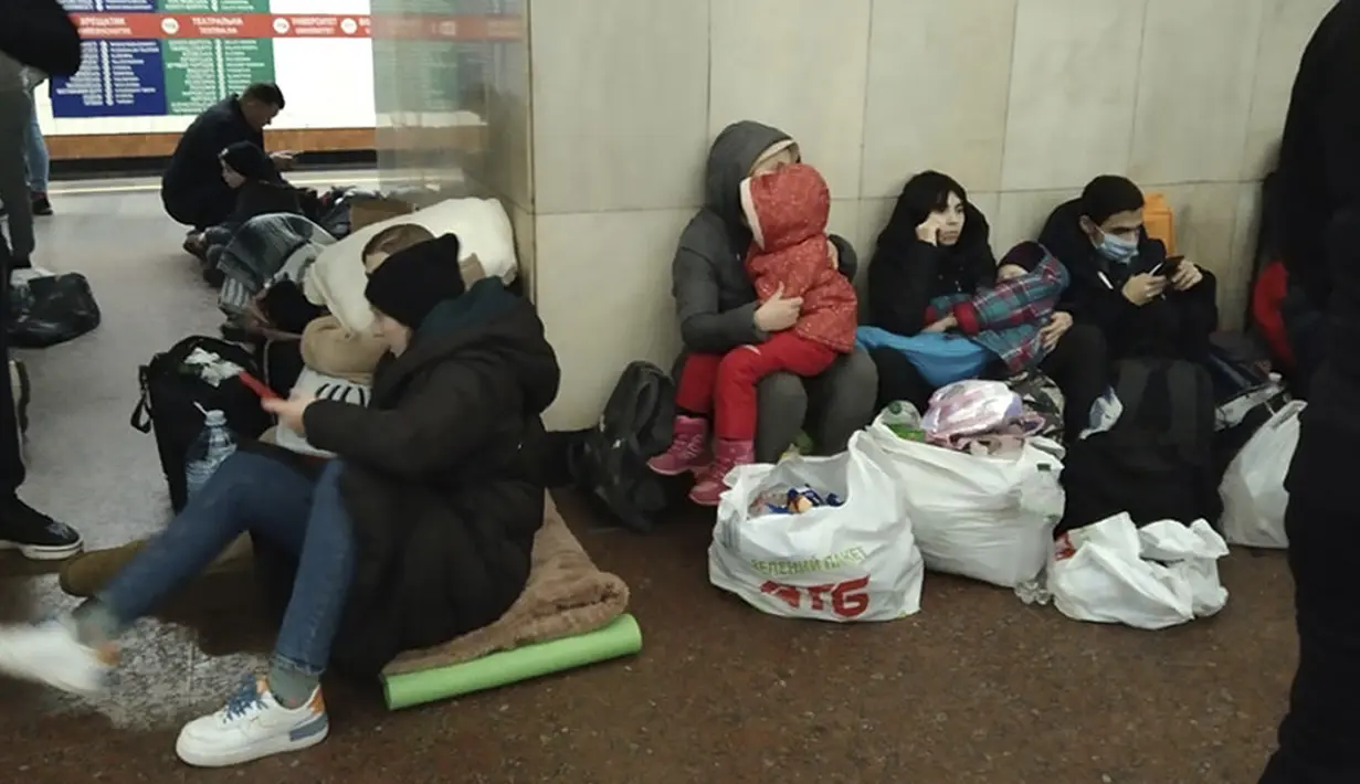 Orang-orang duduk di kereta bawah tanah Kiev, menggunakannya sebagai tempat perlindungan bom di ibu kota Ukraina, Kamis, 24 Februari 2022. Warga di Kiev tampak berlindung di stasiun bawah tanah kota dan tempat-tempat aman lainnya untuk menghindari invasi Rusia. (AP Photo/Emilio Morenatti)