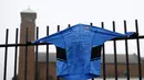 Sebuah kaos olahraga dibentangkan di pagar sekolah oleh para murid yang berduka atas kematian guru bahasa Spanyol mereka, Anne Maguire, Selasa (29/04/2014) (Reuters/Darren Staples).