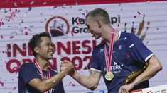 Juara tunggal putra Denmark Viktor Axelsen berjabat tangan dengan runner up dari Indonesia Anthony Sinisuka Ginting saat penyerahan medali usai final tunggal putra Indonesia Open 2023 di Istora Senayan, Minggu (18/6/2023). (AP Photo/Tatan Syuflana)
