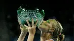 Petenis putri Rusia, Svetlana Kuznetsova, mencium trofi juara turnamen tenis Sydney International setelah di final mengalahkan petenis Puerto Rico, Monica Puig, Minggu (16/1/2016). (Reuters/Jason Reed)