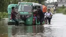 Orang-orang mendorong becak mobil melalui jalan yang banjir di daerah Bagha di Sylhet, Bangladesh (23/5/2022). Banjir bandang pra-musim telah membanjiri bagian dari India dan Bangladesh, menewaskan sedikitnya 24 orang dalam beberapa pekan terakhir dan mengirim 90.000 orang ke tempat penampungan. (AP Photo)