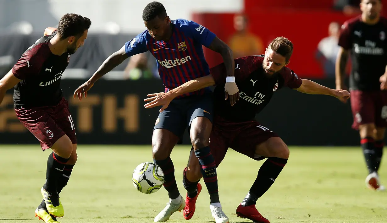 Pemain Barcelona Nelson Semedo berusaha mengontrol bola dari kawalan dua pemain AC Milan saat bertanding pada ICC 2018 di Levi's Stadium di Santa Clara, California (4/8). Milan menang tipis 1-0 atas Barcelona. (AFP Photo/Lachlan Cunningham)