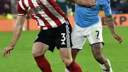 Pemain Sheffield United, Enda Stevens, berebut bola dengan penyerang sayap Manchester City, Raheem Sterling pada pekan ke-24 Liga Inggris di Bramall Lane, Selasa (21/1/2020). Manchester City meraih hasil maksimal usai menang tipis 1-0 atas Sheffield United. (AP/Rui Vieira)