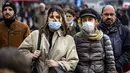 Orang-orang dengan masker melintasi jalan di pusat kota Amsterdam, Belanda, Rabu (3/11/2021). Belanda kembali menerapkan tindakan pembatasan virus corona, termasuk kewajiban memakai masker di berbagai ruang publik menyusul lonjakan kasus Covid-19 beberapa waktu terakhir. (Ramon van Flymen/ANP/AFP)
