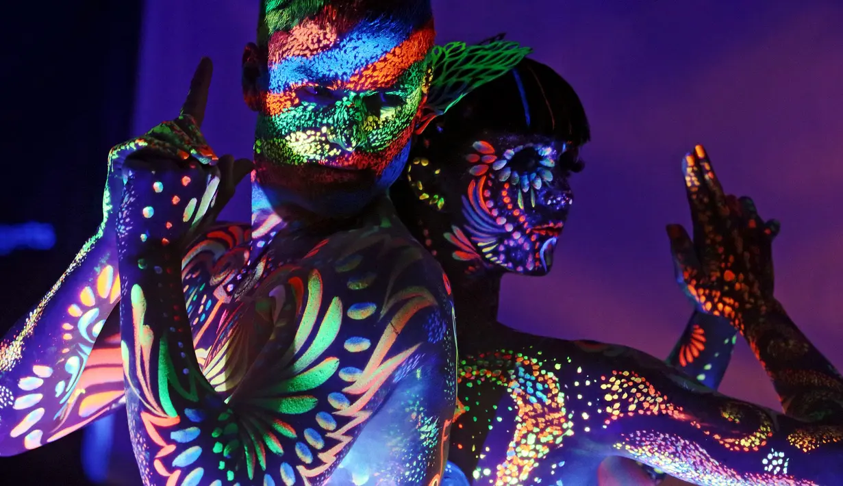Model berpose menampilkan motif dan desain dengan cat lukisan ultraviolet saat mengikuti Festival Bodypainting Dunia 2015 di Poertschach, Austria (3/7/2015). Festival ini digelar di Danau Woerthersee, dari tanggal 3-5 Juli. (Reuters/Heinz-Peter Bade)