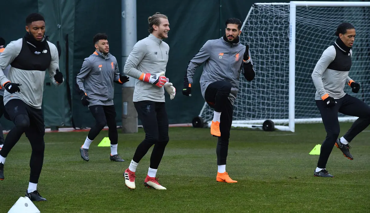 Kiper Liverpool, Loris Karius (kedua kiri) berbincang dengan Emre Can saat melakukan pemanasan saat latihan di Melwood Training Ground, Liverpool, (5/3). Liverpool akan melawan Porto pada leg kedua babak 16 besar Liga Champions. (AFP Photo/Anthony Devlin)
