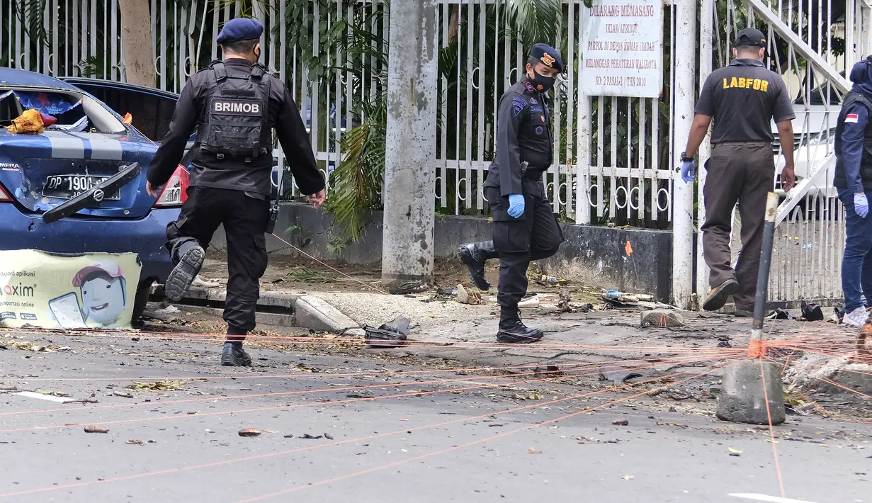 Polisi mengumpulkan bukti dari sekitar lokasi serangan bom di Gereja Katedral Makassar, Sulawesi Selatan, Senin (29/3/2021). Kepolisian masih melakukan olah TKP serta mengumpulkan serpihan sisa ledakan pada hari kedua pascaledakan bom bunuh diri. (AP/Masyudi S. Firmansyah)