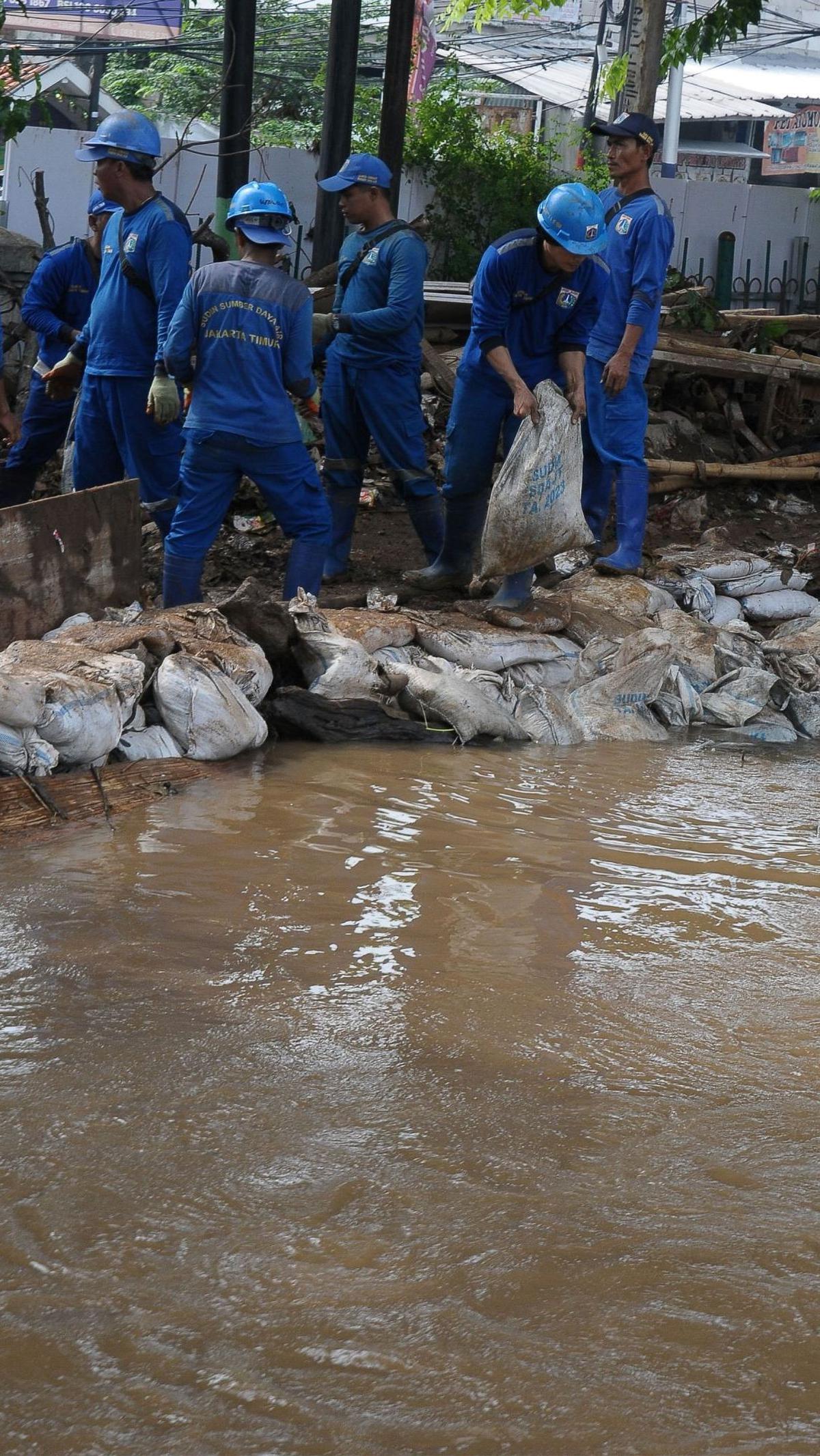 Debit air yang tinggi di aliran kali itu terjadi sekitar pukul 4.45 WIB sehingga menyebabkan banjir setinggi 30 sentimeter  di sekitar pertigaan Hek Kramat Jati. Foto: merdeka.com / Imam Buhori<br>