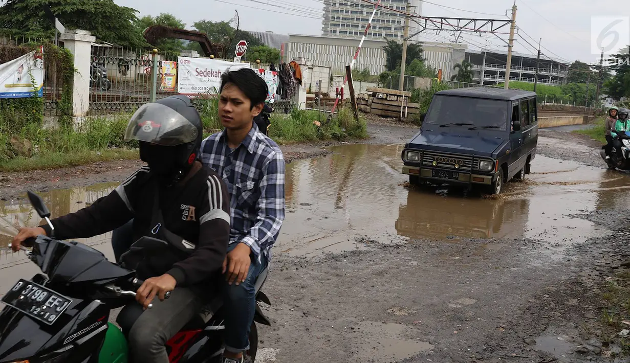 Kendaraan menghindari kubangan pada jalan yang rusak di Jalan Pertamina, Kemiri Muka, Depok, Jawa Barat, Selasa (5/3). Jalan rusak yang telah berlangsung bertahun-tahun tersebut tak kunjung diperbaiki. (Liputan6.com/Immanuel Antonius)