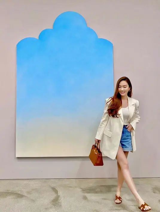 Kali ini, Jessica memadukan tank top warna kuning dengan blazer dan celana pendek jeans. Gayanya dipermanis dengan handbag dan sandal selop warna cokelat. (Instagram/Jessica.syj).