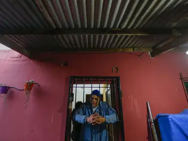Yamil Peralta berpose dari dalam rumahnya di Jose C. Paz di pinggiran Buenos Aires, Argentina, 29 Juli 2020. Di tengah-tengah lockdown akibat COVID-19, petinju Olimpiade dan profesional ini mendapat pekerjaan di perusahaan sampah untuk memenuhi kebutuhannya. (AP Photo/Marcos Brindicci)