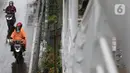 Pengendara mengenakan jas hujan saat melintas di kawasan Kuningan, Jakarta, Kamis (18/12/2021). BMKG memprakirakan potensi hujan lebat yang mungkin disertai petir dan angin kencang hingga 21 Februari di beberapa provinsi di Indonesia, termasuk DKI Jakarta. (Liputan6.com/Helmi Fithriansyah)