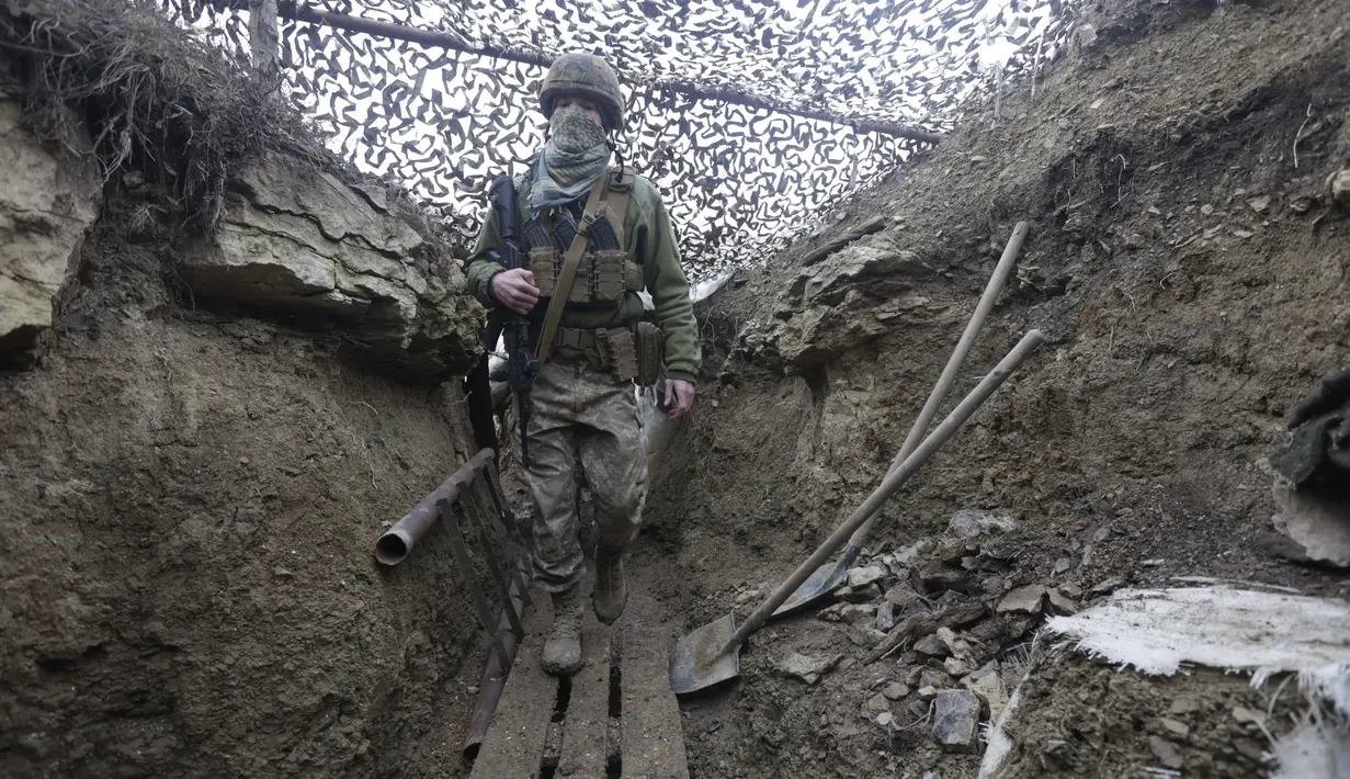 Tentara Ukraina berjalan di bawah jaring kamuflase di parit di garis pemisah dari pemberontak pro-Rusia dekat Debaltsevo, wilayah Donetsk, Ukraina (3/12/2021). Ukraina mengklaim Rusia telah mengirim lebih dari 94 ribu personel ke perbatasan. (AP Photo/Andriy Dubchak)