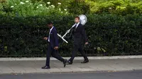 Seorang pria membawa kipas saat dia berjalan di luar Parlemen, London, Inggris, 12 Juli 2022. London akan menghadapi suhu tertinggi 29 C (82 F) minggu ini, sebelum mencapai 31 C (87 F ) pada akhir pekan, menurut Kantor Met Inggris. (AP Photo/Alberto Pezzali)