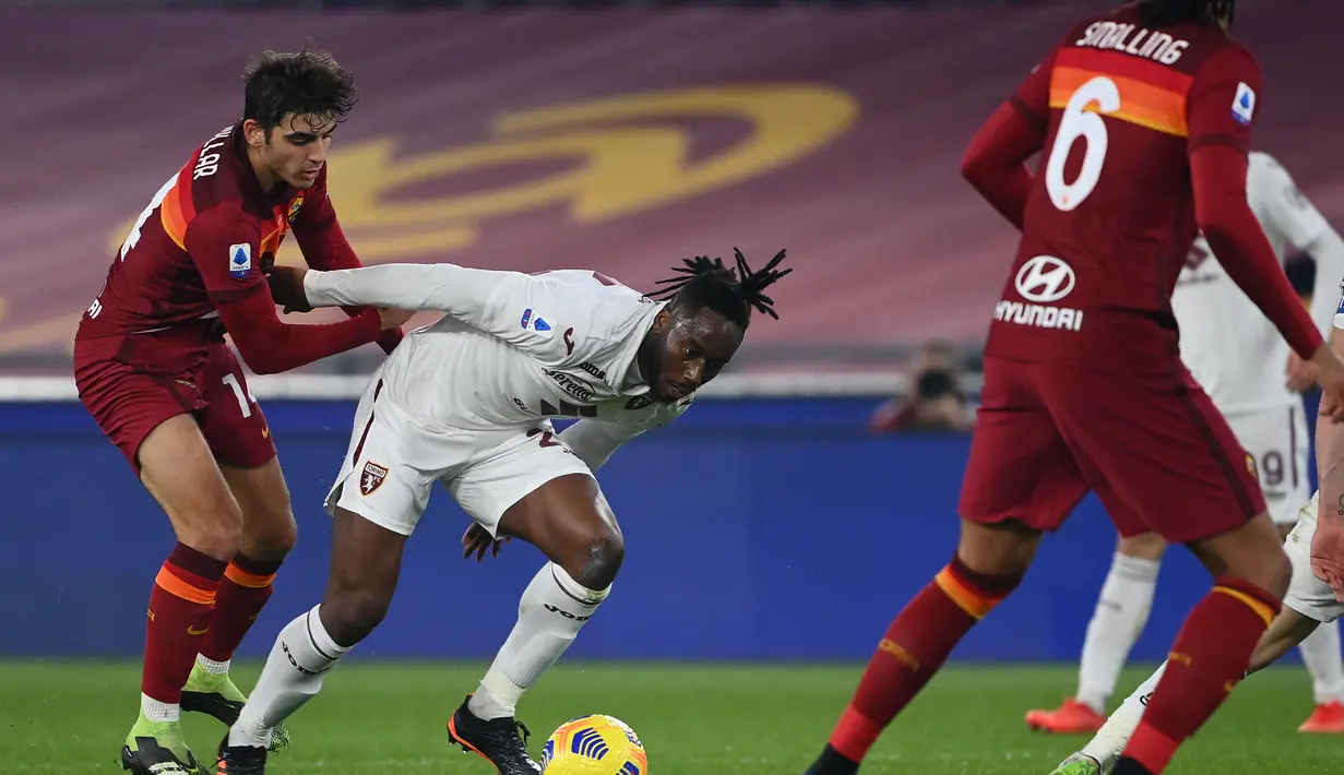 Gelandang Torino, Souahilo Meite membawa bola dari gelandang Roma Gonzalo Villar pada pertandingan Liga Serie A Italia di stadion Olimpiade, Jumat (18/12/2020). Roma berhasil menggusur Napoli. Sedangkan, Torino belum beranjak di zona degradasi dan terpaku di posisi ke-19. (AFP Photo/Vincenzo Pinto)