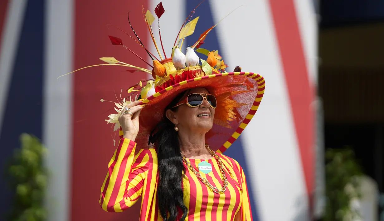 Rebecca Johnson berpose untuk para fotografer dengan mengenakan topi hiasan pada hari pertama pacuan kuda Royal Ascot di Ascot, Inggris, Selasa (15/6/2021). Balap kuda eksklusif yang hanya dihadiri oleh kalangan elit Inggris itu menjadi tradisi tahunan sejak tahun 1711. (AP Photo/Alastair Grant)