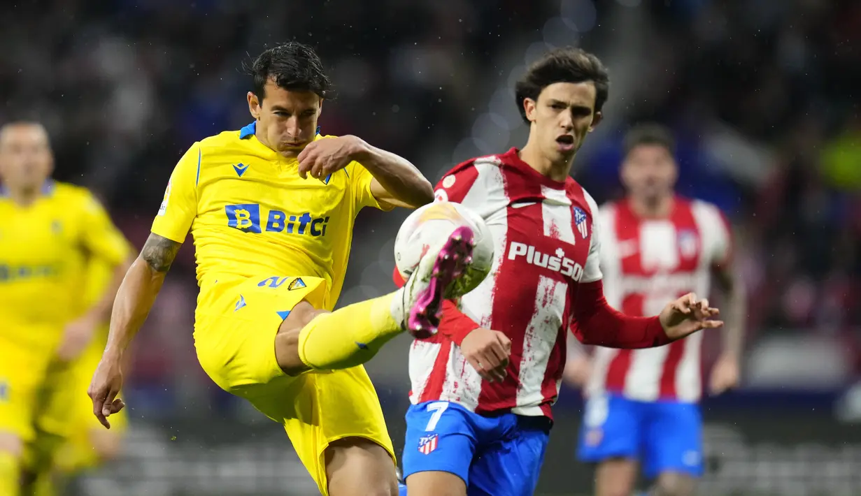 Bek Cadiz Luis Hernandez berebut bola dengan penyerang Atletico Madrid Joao Felix pada jornada ke-28 Liga Spanyol di Stadion Wanda Metropolitano, Sabtu (12/3/2022) dini hari WIB. Atletico Madrid sukses meraih kemenangan 2-1 atas tamunya Cadiz. (AP Photo/Manu Fernandez)
