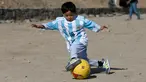 Murtaza Ahmadi (5), bocah asal Afghanistan, memakai jersey yang ditandatangani langsung oleh bintang Barcelona yang juga idolanya, Lionel Messi, ketika bermain sepak bola di sebuah lapangan terbuka di Kabul, Jumat (26/2). (REUTERS/Omar Sobhani)
