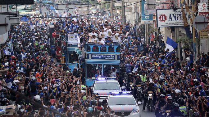 Warga Bandung menyambut pemain Persib di sepanjang rute yang dilalui saat berlangsungnya Pawai Persib Juara Piala Presiden, Minggu (25/10/2015). (Bola.com/Nicklas Hanoatubun)