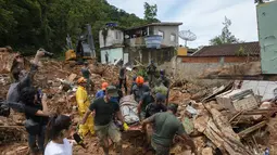 Petugas penyelamat dan relawan membawa jenazah korban longsor di dekat pantai Barra do Sahy setelah hujan lebat di kota pesisir Sao Sebastiao, Brasil, Rabu, 22 Februari 2023. Sekitar 1.730 orang telah mengungsi dan 1.810 kehilangan tempat tinggal, menurut pemerintah negara bagian Sao Paulo. (AP Photo/Andre Penner)