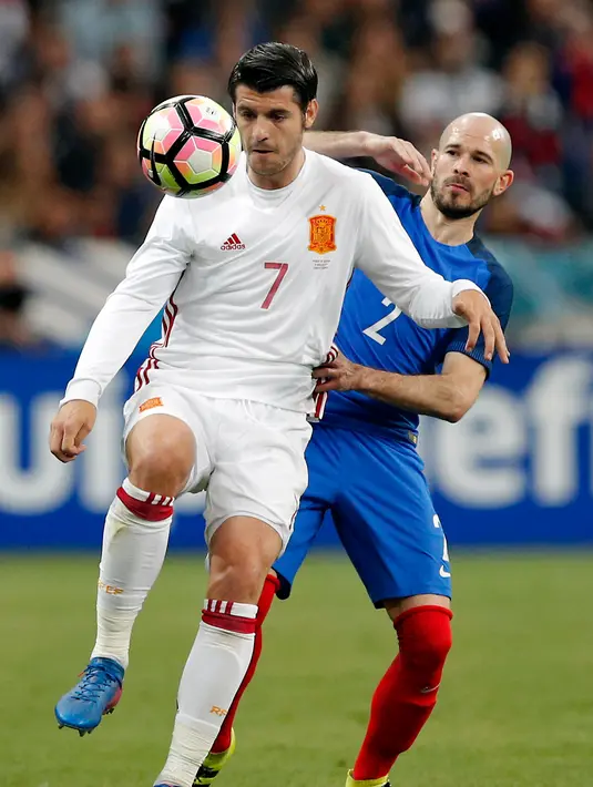 Penyerang Spanyol, Alvaro Morata berusaha mengontrol bola dari kawalan bek Prancis, Christophe Jallet pada laga persahabatan di Paris, (29/3). Spanyol menang atas Prancis dengan skor 2-0. (AP Photo / Christophe Ena)