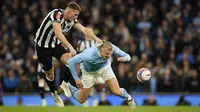 Pemain Manchester City, Erling Haaland, terjatuh saat berebut bola dengan pemain Newcastle United, Sven Botman, pada laga Piala FA di Stadion Etihad, Minggu (17/3/2024). (AP Photo/Dave Thompson)