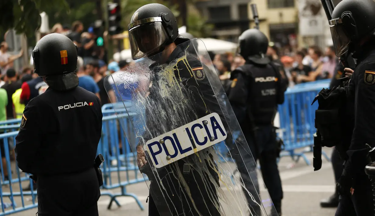 Polisi berjaga di lokasi aksi sopir taksi Spanyol, Madrid, Selasa (30/5). Demonstran menganggap layanan mobil berbasis online yang murah bisa menyebabkan layanan taksi ditinggalkan penumpang. (AP Photo / Francisco Seco)